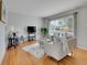 Open living room with hardwood floors, window views, and a comfortable seating arrangement at 2797 S Newton Way, Denver, CO 80236