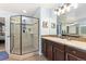 Bright bathroom featuring glass-enclosed shower, dark wood vanity, and updated fixtures and finishes at 2342 Hickory Pl, Erie, CO 80516