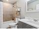 Bathroom featuring a shower over tub, grey vanity with quartz countertop and a white framed mirror at 2342 Hickory Pl, Erie, CO 80516