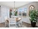 Bright dining area features wood flooring, large windows, stylish lighting, and access to the outdoor patio at 2342 Hickory Pl, Erie, CO 80516