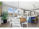 Open concept dining area with wood flooring and views into the modern kitchen, great for entertaining at 2342 Hickory Pl, Erie, CO 80516