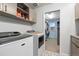 Bright laundry room features modern washer and dryer, built-in cabinets, and a view into the closet at 2342 Hickory Pl, Erie, CO 80516