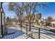 City view from balcony overlooking quiet street with snow covered landscaping, trees and homes at 374 S Humboldt St, Denver, CO 80209