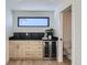 Bar area featuring a wine refrigerator, sleek black countertops and backsplash, and access to a powder room at 374 S Humboldt St, Denver, CO 80209