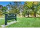 Entrance to Washington Park showing a green lawn, mature trees, and a green iron sign at 374 S Humboldt St, Denver, CO 80209