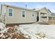 Exterior view of the house with a small porch in a snowy backyard at 3887 Grand Baker St, Aurora, CO 80019