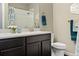 Bathroom featuring dual sinks, a dark wood vanity, and white and blue accents, creating a cozy ambiance at 3887 Grand Baker St, Aurora, CO 80019