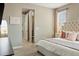 Bedroom featuring a tufted headboard, with a glimpse into the en-suite bathroom at 3887 Grand Baker St, Aurora, CO 80019