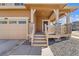 Inviting covered front porch with stone-accented posts, a two-car garage, and a well-maintained exterior at 9048 Bondcliff, Parker, CO 80134