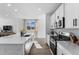 Bright kitchen features white cabinetry, stainless steel appliances, and a large island with quartz countertops at 9048 Bondcliff, Parker, CO 80134