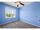 Bedroom featuring blue walls, carpet, a ceiling fan, and a window with natural light at 19524 Montview Dr, Aurora, CO 80011