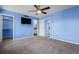 Bedroom with blue walls, carpet, TV, and walk-in closet, creating a comfortable retreat at 19524 Montview Dr, Aurora, CO 80011