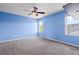 Bedroom featuring blue walls, carpet, a ceiling fan, and two windows with natural light at 19524 Montview Dr, Aurora, CO 80011