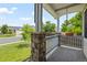 Covered porch with stone pillars, a swing, and a view of the landscaped front yard at 19524 Montview Dr, Aurora, CO 80011