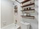 Bathroom featuring a tiled shower/tub with shelves and toiletries at 2835 S Monaco Pkwy # 1-103, Denver, CO 80222