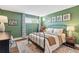 Green bedroom featuring a comfortable bed, decor, and soft natural light, with modern accents at 2835 S Monaco Pkwy # 1-103, Denver, CO 80222