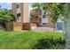 Attractive brick apartment building with balconies overlooking a lush green lawn and trees at 2835 S Monaco Pkwy # 1-103, Denver, CO 80222