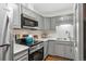 Stylish kitchen with stainless steel appliances, marble countertop, and grey cabinetry at 2835 S Monaco Pkwy # 1-103, Denver, CO 80222