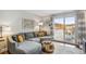 Comfortable living room featuring a gray sectional sofa, artwork, and sliding glass door to the outdoor patio at 2835 S Monaco Pkwy # 1-103, Denver, CO 80222