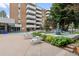Outdoor pool area with comfortable lounge chairs, a decorative fountain, and lush landscaping at 2835 S Monaco Pkwy # 1-103, Denver, CO 80222