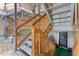 Apartment staircase with wooden railings leading to upper levels, with decorative front door and potted plants at 2835 S Monaco Pkwy # 1-103, Denver, CO 80222