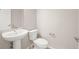 Clean powder bathroom with a sleek pedestal sink, neutral walls, and tile floors at 20871 E 60Th Ave, Aurora, CO 80019