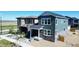 Modern home featuring gray siding, stone accents, covered porch and a well-manicured lawn at 20871 E 60Th Ave, Aurora, CO 80019