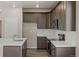 Modern kitchen featuring white backsplash, stainless appliances, and dark cabinets, providing a sleek cooking space at 20871 E 60Th Ave, Aurora, CO 80019