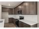 Well-designed kitchen featuring stainless appliances, dark wood cabinets, and white countertops, offering a modern space at 20871 E 60Th Ave, Aurora, CO 80019