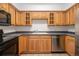 Kitchen featuring stainless steel dishwasher, wooden cabinets, and black appliances at 1020 15Th St # 15G, Denver, CO 80202