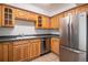 This kitchen includes stainless steel refrigerator, tile floors and wooden cabinetry at 1020 15Th St # 15G, Denver, CO 80202