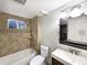 Clean bathroom with tiled walls and tub, vanity with sink, and modern toilet at 945 W 8Th Avenue Dr, Broomfield, CO 80020