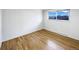 Bright, empty bedroom with hardwood floors and a large window overlooking a quiet street at 945 W 8Th Avenue Dr, Broomfield, CO 80020