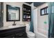 Well-lit bathroom featuring a black vanity and shower with curtain at 17233 E Princeton Dr, Aurora, CO 80013