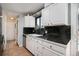 Bright kitchen featuring white cabinets, a black countertop, and stainless steel dishwasher at 17233 E Princeton Dr, Aurora, CO 80013