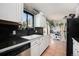 Clean kitchen featuring white cabinets and a black countertop with a stainless steel dishwasher at 17233 E Princeton Dr, Aurora, CO 80013