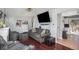 Comfortable living area featuring hardwood floors, a plush sofa, and modern wall-mounted television at 17233 E Princeton Dr, Aurora, CO 80013