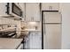 Well-lit kitchen boasts stainless steel appliances and modern gray cabinets with black hardware at 4025 Jason St # 101, Denver, CO 80211