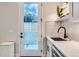 Convenient mud room area with exterior access door and tiled backsplash over the utility sink at 4025 Jason St # 101, Denver, CO 80211