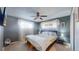 Cozy bedroom with ceiling fan, carpet floors, and bright natural light coming in through the windows at 7081 Warren Dr, Denver, CO 80221