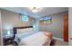Cozy bedroom featuring plush bedding, a mounted TV, and unique stained glass lighting fixture at 7081 Warren Dr, Denver, CO 80221