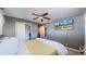 Relaxing bedroom with carpet floors, a ceiling fan, and an exterior view shown on the wall-mounted television at 7081 Warren Dr, Denver, CO 80221