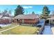 Charming brick home featuring a well-maintained lawn, covered porch, and convenient carport, perfect for curb appeal at 7081 Warren Dr, Denver, CO 80221