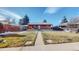 Quaint brick home featuring a well-maintained front lawn and a convenient carport at 7081 Warren Dr, Denver, CO 80221