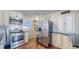 Charming kitchen features stainless steel appliances, subway tile backsplash, and white cabinetry at 7081 Warren Dr, Denver, CO 80221