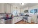 Modern kitchen with stainless steel appliances, white cabinetry, and black countertops and tile backsplash at 7081 Warren Dr, Denver, CO 80221