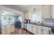 Open concept kitchen with white cabinetry, black countertops, and a stainless steel dishwasher at 7081 Warren Dr, Denver, CO 80221