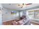 Cozy living room with a ceiling fan, mounted TV, and a view of the front yard, offering a comfortable living space at 7081 Warren Dr, Denver, CO 80221