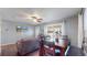 Open-concept living and dining area featuring hardwood floors, a ceiling fan, and ample natural light for comfortable living at 7081 Warren Dr, Denver, CO 80221