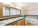 Bright bathroom featuring double sinks, a large mirror, and a soaking tub with marble tile at 7400 W Grant Ranch Blvd # 52, Littleton, CO 80123